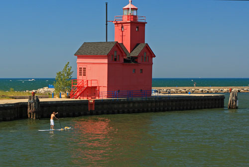 paddling boarding past the big red lighthouse in holland